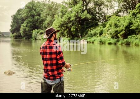 Je pêche. Activités de loisir et de sport. Pothunter. Week-end d'été. Pêche au gros gibier. Pêcheur avec canne à pêche. Pêcheur barbu dans l'eau. Homme mature pêche à la mouche. Homme attrapant le poisson. Banque D'Images