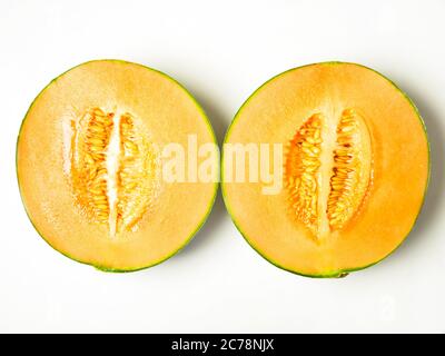 Melon de canteloup divisé en deux avec des graines isolées sur fond blanc Banque D'Images