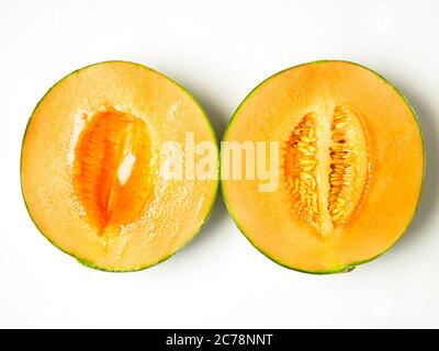 Deux moitiés d'un melon de canteloup, une avec des graines et une sans isolé sur fond blanc Banque D'Images