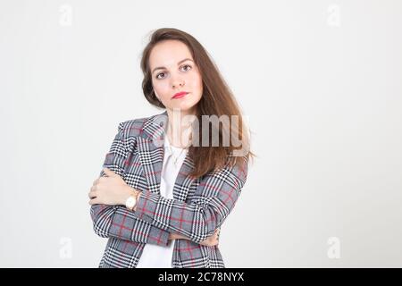 belle jeune femme en affaires vêtements stricts pose contre un mur blanc Banque D'Images