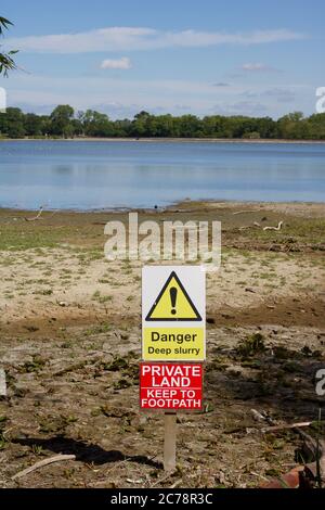 Plancher du réservoir séché présentant un signe de danger indiquant une boue profonde Banque D'Images