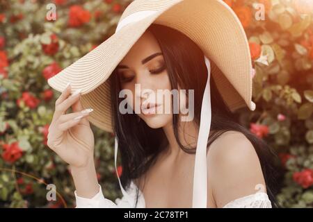 Femme de mode en robe et chapeau en roses Banque D'Images