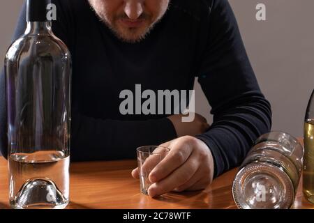 Un homme en intoxication alcoolique détient un verre d'alcool. Alcoolisme, toxicomanie, délire Banque D'Images