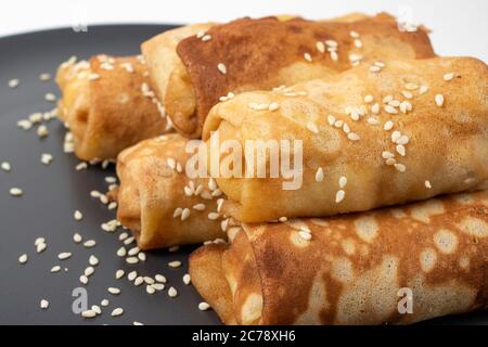 Gros plan sur un plat de foie gras avec du pain français croustillant au sésame de style campagnard et de la pancake russe blini isolée sur du blanc Banque D'Images