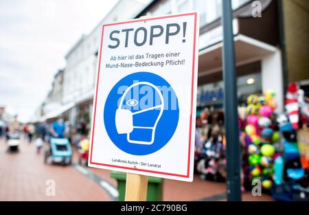 Norderney, Allemagne. 15 juillet 2020. Un panneau indiquant « Stop! A partir d'ici, il est obligatoire de porter une couverture de bouche-nez" est écrit dans la zone piétonne de l'île. Sur l'île de la Frise orientale, les touristes et les habitants doivent porter un masque facial dans certaines zones du centre-ville. Credit: Hauke-Christian Dittrich/dpa/Alay Live News Banque D'Images