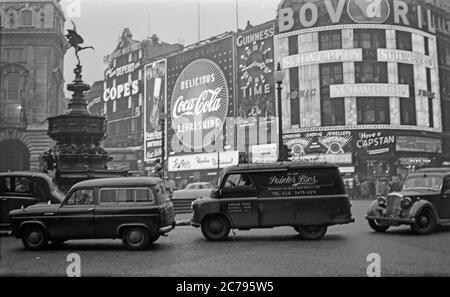 Photographie vintage des années 1950 de Piccadilly Circus à Londres, Angleterre. Affiche les signes publicitaires néons de l'époque, y compris Coca Cola, Bovril, Guinness, toujours prêt. Aussi des voitures et des fourgonnettes de l'époque. Banque D'Images