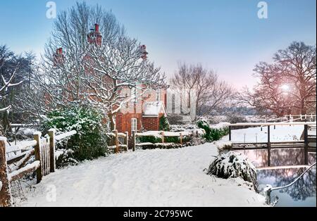 SNOW RIVER WAY lever de soleil d'hiver au-dessus de Papercourt Lock et le chalet de gardiens de écluses enneigées sur le chemin de halage de River Wey après la chute de neige récente Surrey Angleterre Royaume-Uni Banque D'Images