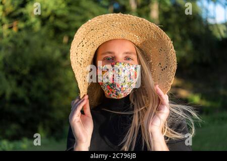 Belle jeune femme portant un masque facial élégant et tendance pour coronavirus couvrant pendant le verrouillage pandémique Covid-19 Banque D'Images