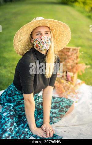 Belle jeune femme souriante et portant un masque facial tendance et élégant pour protéger contre la pandémie Covid-19 Banque D'Images