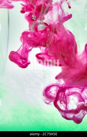 Une photographie de gros plan de couleur rose et verte mélangée dans l'eau. Banque D'Images