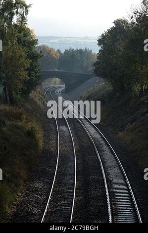 Voie ferrée vide passant sous un pont dans la campagne anglaise. Banque D'Images