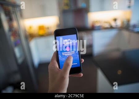 POV Man utilisant l'ID de touche sur le smartphone dans la cuisine Banque D'Images