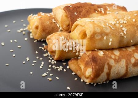 Gros plan sur un plat de foie gras avec du pain français croustillant au sésame de style campagnard et de la pancake russe blini isolée sur du blanc Banque D'Images