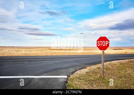 Stop Road à une intersection dans le parc national de Badlands, Dakota du Sud, États-Unis. Banque D'Images