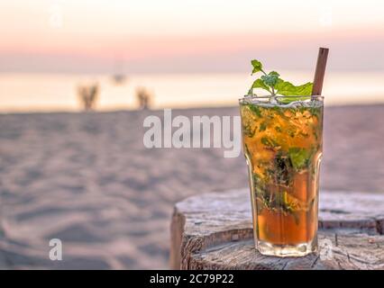 buvez avec la plage floue et le coucher du soleil en arrière-plan Banque D'Images