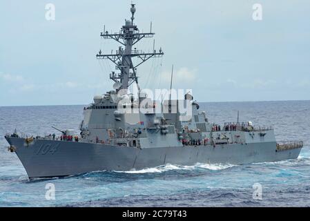 Le destroyer de missiles guidés USS Sterett de la Marine américaine Arleigh Burke part avant un réapprovisionnement en mer avec le porte-avions USS Nimitz le 14 juillet 2020 en mer des Philippines. Banque D'Images