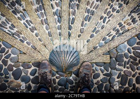Le chemin de saint James ou compostelle . des chaussures de marche bien portées avec coquille de pétoncle.Nasbinals Lozere, France. Banque D'Images