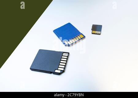 Gros plan de trois cartes micro SD, produits technologiques, mise au point sélective. Cartes mémoire SD sur une surface blanche Banque D'Images