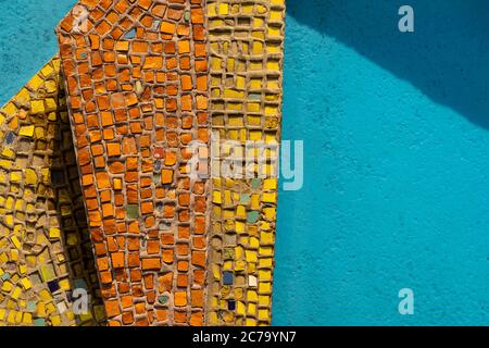 petits carreaux de mosaïque orange et jaune sur le sol en pierre bleue. sol en mosaïque coloré dans la piscine d'eau Banque D'Images