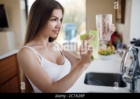 Belle femme faisant le nettoyage à la maison et laver la vaisselle Banque D'Images