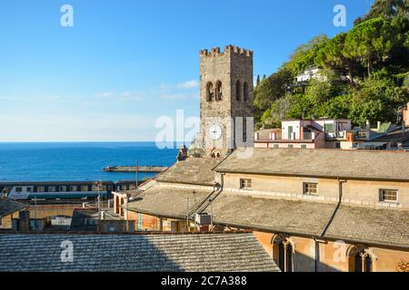 La tour de Chiesa di San Giovanni Battista avec la mer Ligure au-delà comme un train passe à Monterosso al Mare, Cinque Terre Italie lors d'une journée ensoleillée Banque D'Images