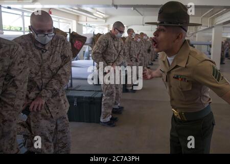 Un instructeur de forage de Marine américaine, Yells instructions de recruter avec Alpha Company, 1er Bataillon d'entraînement de recrutement, pendant l'entraînement au dépôt de recrutement de corps de Marine le 19 juin 2020 à San Diego, Californie. Banque D'Images