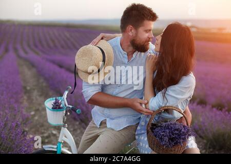 couple heureux dans le champ de laveder. homme et femme dans la lumière du coucher de soleil dans la lavande en fleur Banque D'Images