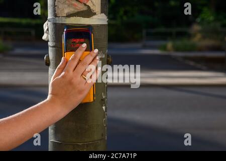 Un gros plan d'une main femelle adulte donne un signal d'arrêt sans contact pour la traversée des piétons en Allemagne Banque D'Images