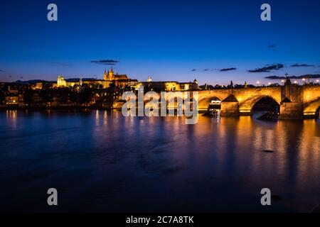 Pont Charles à Prague la nuit, traversant la Vltava avec la cathédrale Saint-Vitus et le château de Prague Banque D'Images
