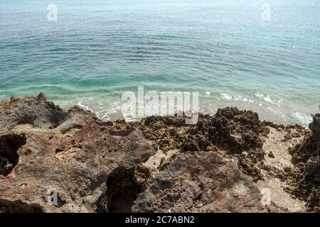 Une plage rocheuse avec de l'eau turquoise claire à Stuart, FL, un jour ensoleillé. Banque D'Images