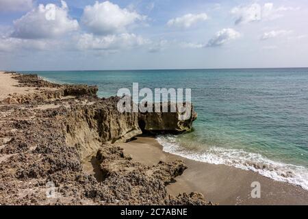 Une plage rocheuse avec de l'eau turquoise claire à Stuart, FL, un jour ensoleillé. Banque D'Images