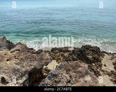 Une plage rocheuse avec de l'eau turquoise claire à Stuart, FL, un jour ensoleillé. Banque D'Images