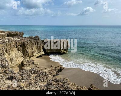 Une plage rocheuse avec de l'eau turquoise claire à Stuart, FL, un jour ensoleillé. Banque D'Images