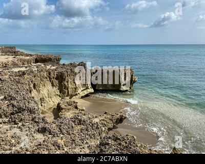 Une plage rocheuse avec de l'eau turquoise claire à Stuart, FL, un jour ensoleillé. Banque D'Images