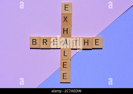 Respirez, exhalez, les mots en lettres de l'alphabet en bois 3D en forme de mots croisés isolés sur fond coloré Banque D'Images