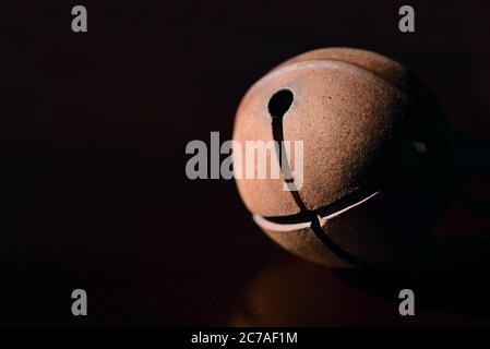 Une cloche ronde en métal ancien sur fond sombre Banque D'Images