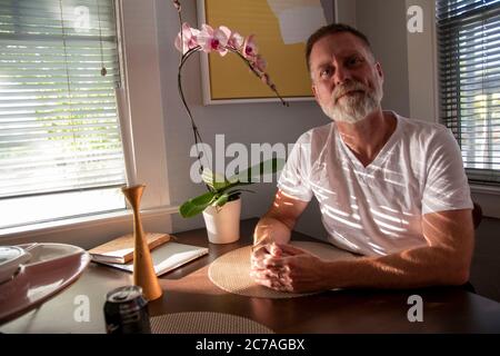 Cet homme pose pour une photo dans son nouvel appartement à Oakland, CA. Banque D'Images