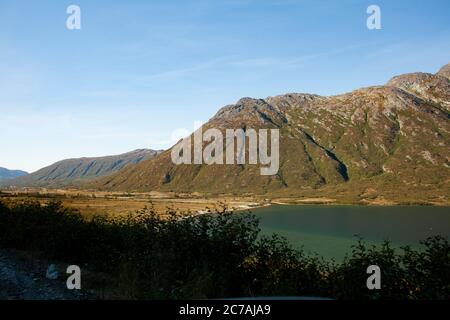 Une vallée sereine en Alaska avec un lac calme niché entre des montagnes escarpées, mettant en valeur la beauté intacte et la tranquillité de la nature sauvage. Banque D'Images