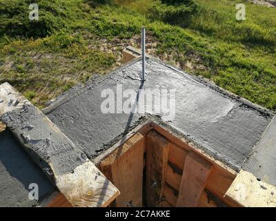 Vis métalliques insérées dans le béton humide pour la fixation sur le toit d'une maison individuelle Banque D'Images