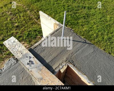 Vis métalliques insérées dans le béton humide pour la fixation sur le toit d'une maison individuelle Banque D'Images