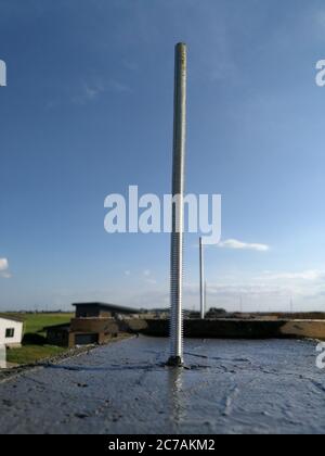 Vis métalliques insérées dans le béton humide pour la fixation sur le toit d'une maison individuelle Banque D'Images