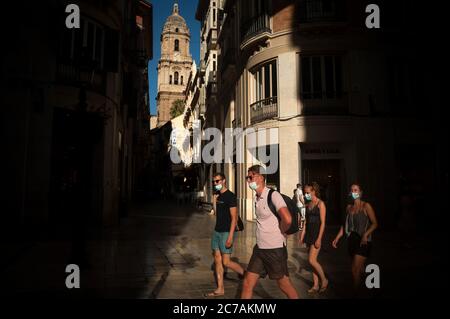 Malaga, Espagne. 15 juillet 2020. Les touristes portant des masques de visage marchant devant la cathédrale de Malaga le long de la rue marques de Larios pendant le premier jour de l'utilisation obligatoire des masques de visage.de nouvelles infections coronavirus en Espagne après l'assouplissement des restrictions ont poussé le gouvernement régional à imposer l'utilisation obligatoire des masques de visage à l'extérieur et des lieux fermés et des plages, même quand ils observent une distance de sécurité entre les gens. Cette mesure vise à freiner la propagation de la pandémie du coronavirus. Crédit: Jesus Merida/SOPA Images/ZUMA Wire/Alay Live News Banque D'Images