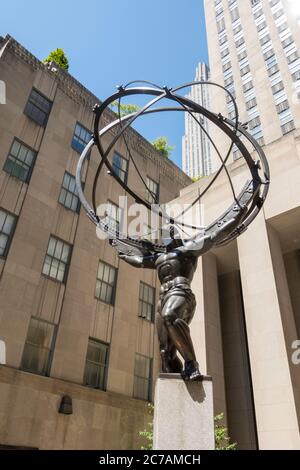 L'ancien Titan grec Atlas tenant les cieux Bronze Armillary sphère Sculpture au Rockefeller Center portant un masque de visage dû à COVID-19, NYC, USA Banque D'Images