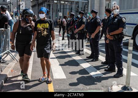 Brooklyn, New York, États-Unis. 125e juillet 2020. Deux militants de Black Lives Matter marchent le 15 juillet 2020, à New York, devant une ligne d'officiers du NYPD qui gardaient un bus du département des corrections de New York. (Photo de Gabriele Holtermann/Sipa USA) crédit: SIPA USA/Alay Live News Banque D'Images