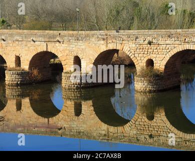 Merida, province de Badajoz, Extremadura, Espagne. Le pont romain qui se reflète sur la rivière Guadiana. Patrimoine mondial de l'UNESCO. Banque D'Images