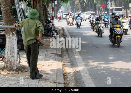 HANOI, VIETNAM, APR 20 2019, HANOI, UN homme dans un ensemble militaire vert surveille la circulation sur la rue Banque D'Images