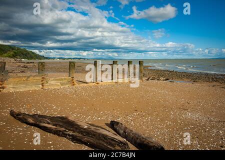 L'ancien quai poste en rangée sur la plage à marée basse sur la plage de Tararu Tames Nouvelle-Zélande Banque D'Images