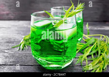 Limonade à l'estragon avec glace en deux verres, branches d'estragon sur fond de bois foncé Banque D'Images