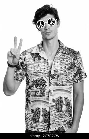 Jeune homme beau portant des lunettes de soleil avec signe de paix tout en donnant le geste de signe de paix Banque D'Images