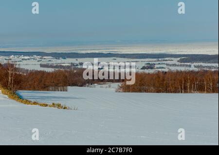 Vue sur le paysage d'hiver près d'Abashiri, une ville sur l'île Hokkaido, Japon avec la mer d'Okhotsk en arrière-plan. Banque D'Images